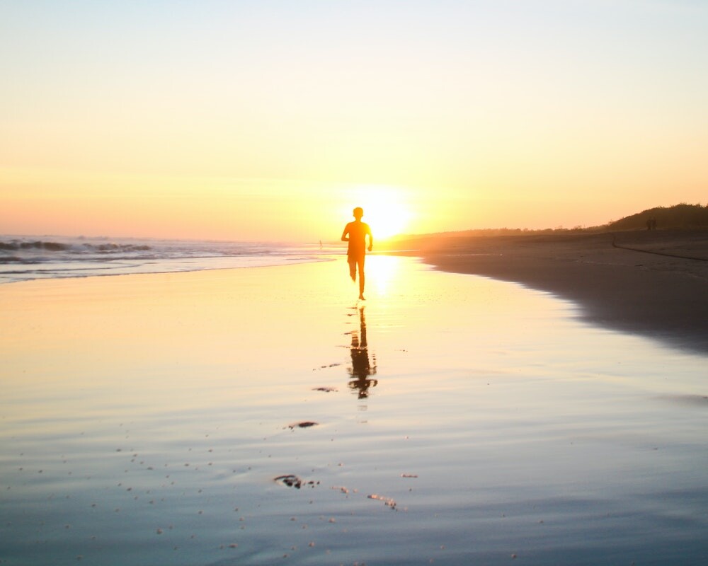 boy running along south padre island 