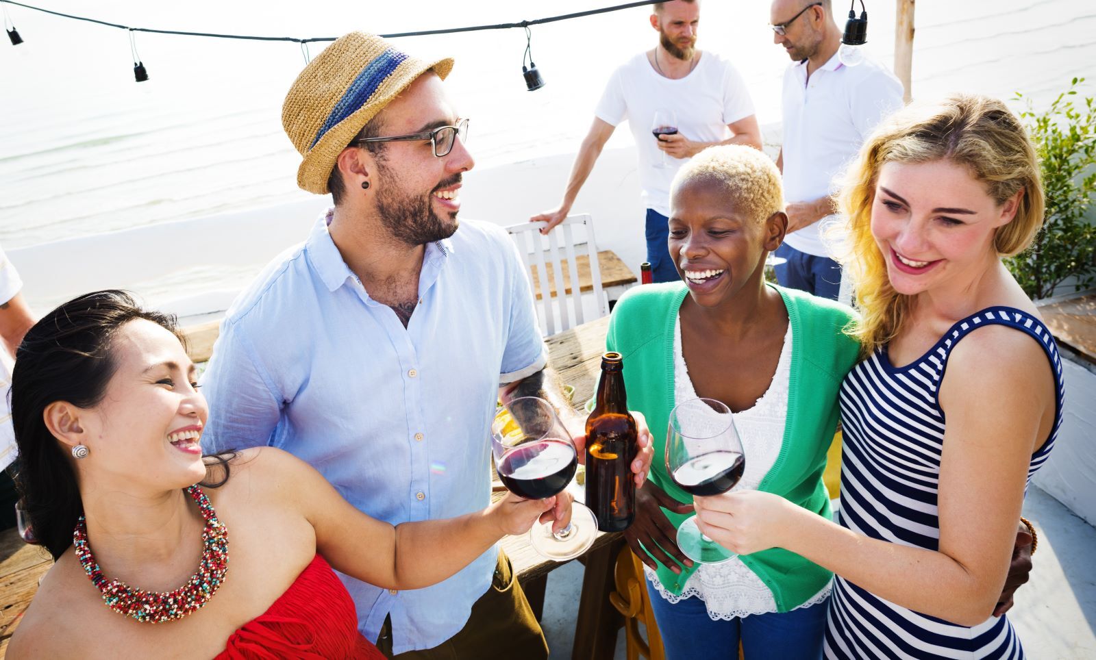 Friends-toasting-drinks-at-outdoor-parties | South Padre Island Vacation Rentals Friends enjoying drinks at waterfront bar