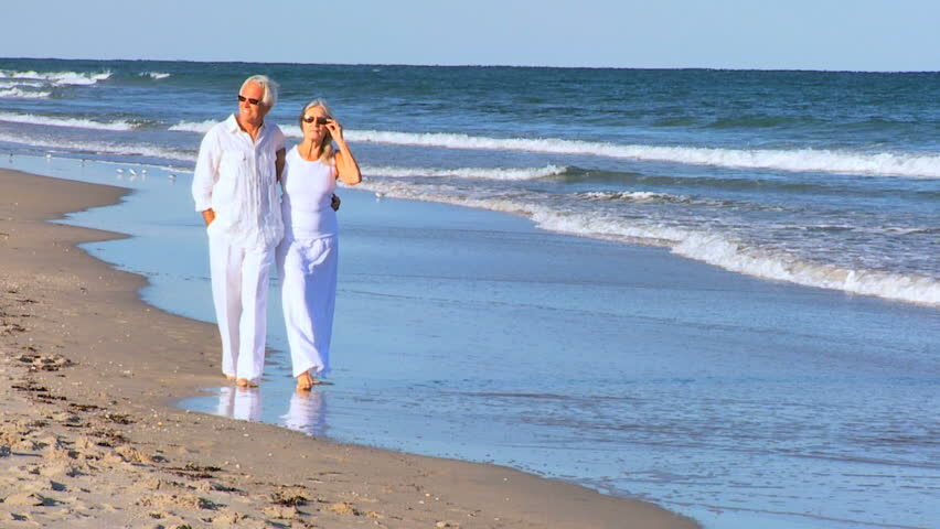 Couples-walking-along-the-shoreline | South Padre Island Vacation Rentals older couple strolls along the beach shore
